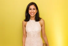 Professional portrait of Seema Mody, CNBC technology and global markets correspondent, smiling in white top against gray background, highlighting her expertise in AI reporting and financial journalism for 2025 trends.