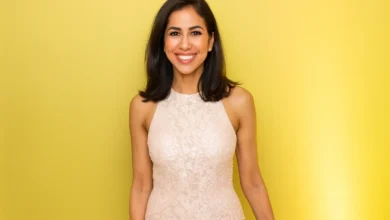 Professional portrait of Seema Mody, CNBC technology and global markets correspondent, smiling in white top against gray background, highlighting her expertise in AI reporting and financial journalism for 2025 trends.
