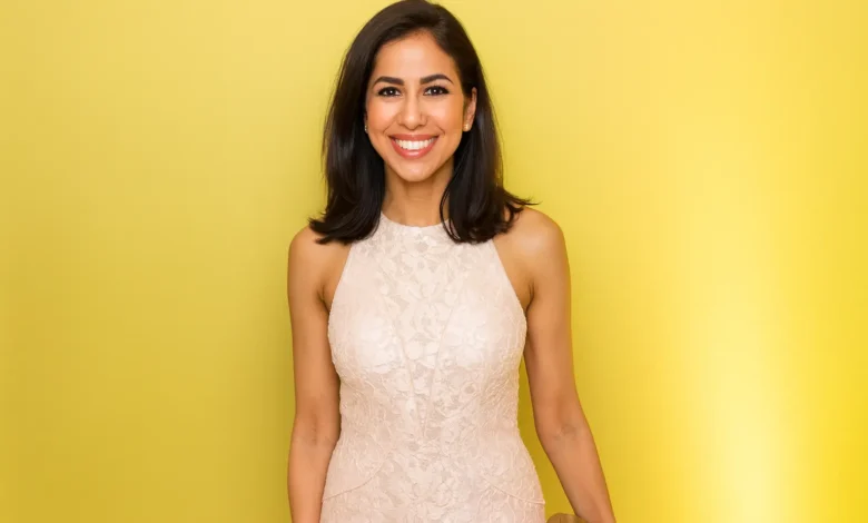 Professional portrait of Seema Mody, CNBC technology and global markets correspondent, smiling in white top against gray background, highlighting her expertise in AI reporting and financial journalism for 2025 trends.